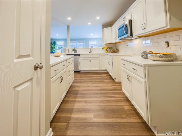 kitchen featuring white cabinetry, sink, appliances with stainless steel finishes, and light wood-type flooring