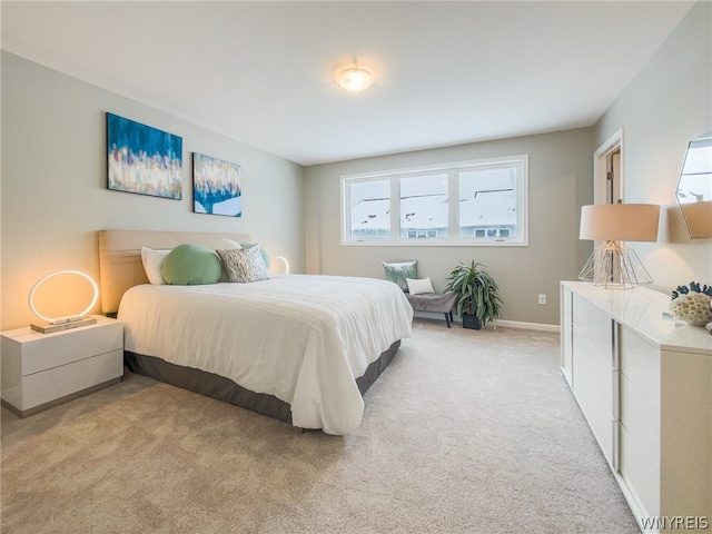 bedroom featuring light colored carpet and multiple windows