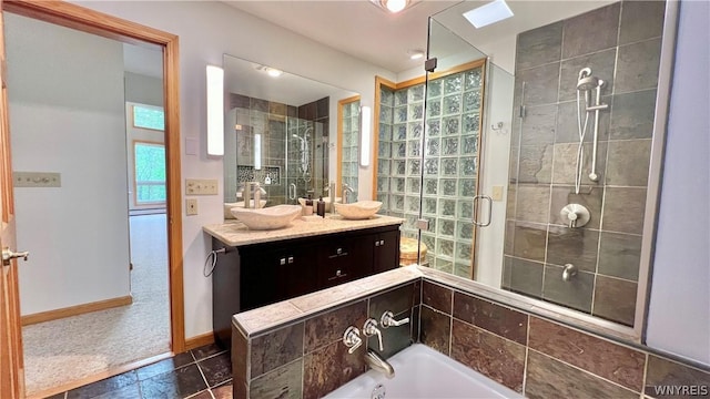 bathroom with plus walk in shower, vanity, a skylight, and tile patterned flooring