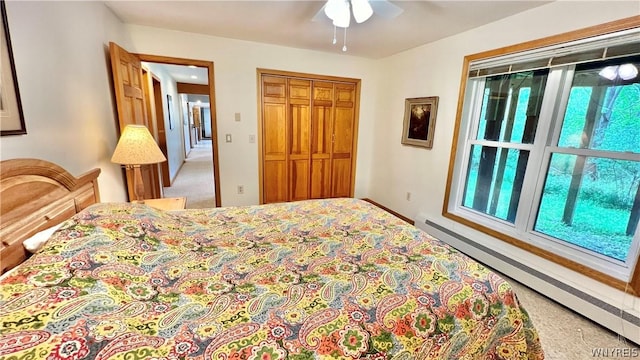 bedroom with carpet, ceiling fan, baseboard heating, and a closet