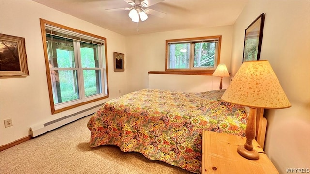 carpeted bedroom featuring ceiling fan and a baseboard heating unit