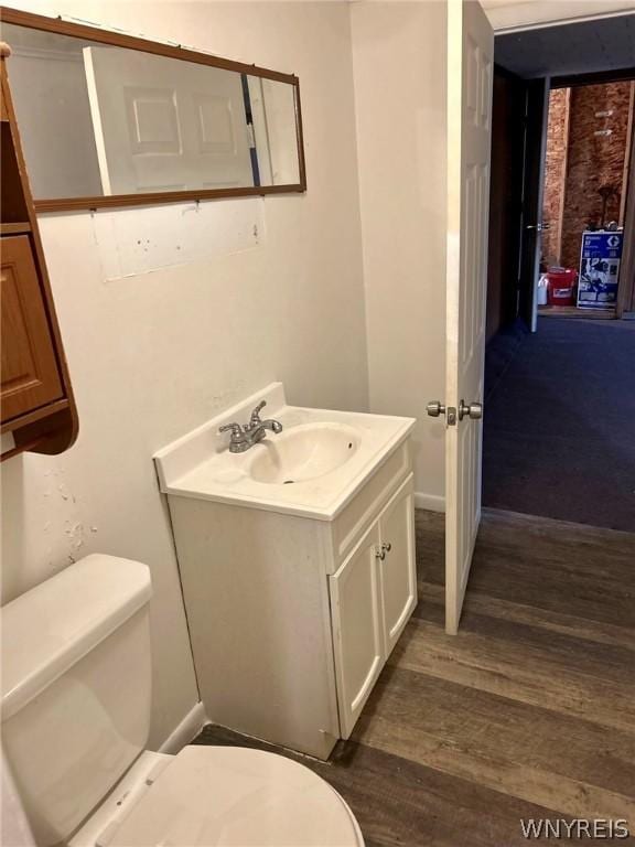 bathroom with hardwood / wood-style flooring, vanity, and toilet