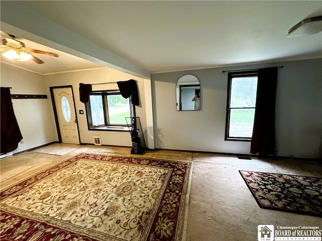 foyer featuring crown molding, carpet flooring, and ceiling fan