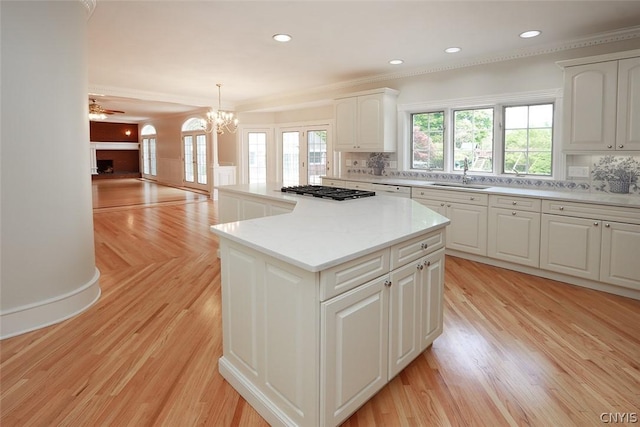 kitchen featuring pendant lighting, a center island, white cabinetry, and sink