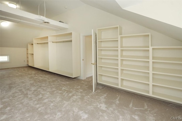 spacious closet featuring light carpet and vaulted ceiling