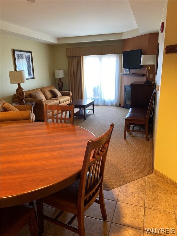 dining space featuring tile floors and a tray ceiling