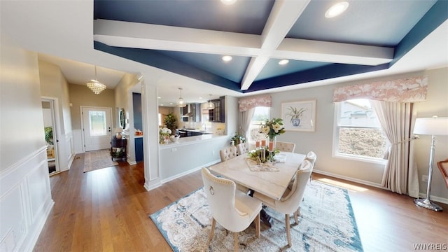 dining area featuring hardwood / wood-style floors, a chandelier, beam ceiling, and coffered ceiling