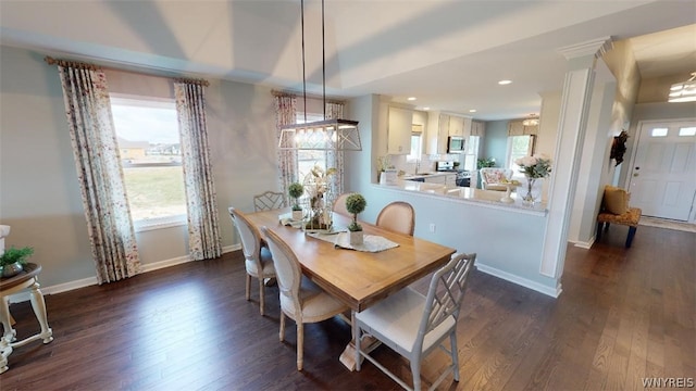 dining area with dark hardwood / wood-style flooring, decorative columns, and sink