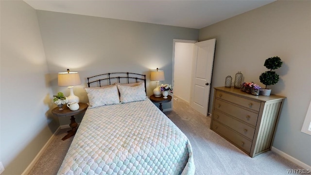 bedroom featuring light carpet and baseboards