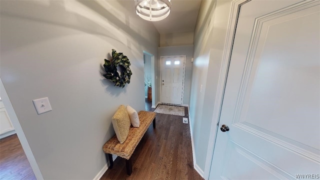 doorway with wood finished floors and baseboards