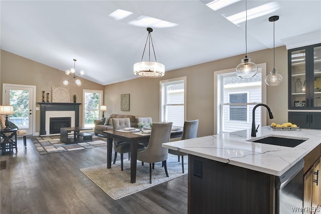 dining space with a chandelier, dark wood-type flooring, lofted ceiling, and sink