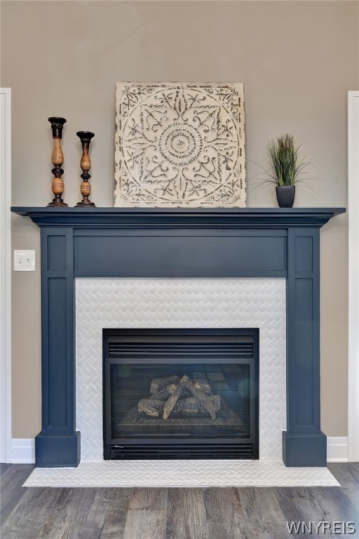 interior details featuring hardwood / wood-style floors and a tiled fireplace