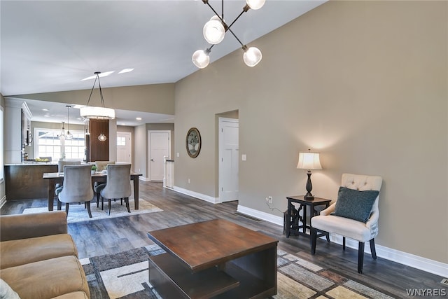 living room featuring dark hardwood / wood-style flooring, high vaulted ceiling, and a chandelier