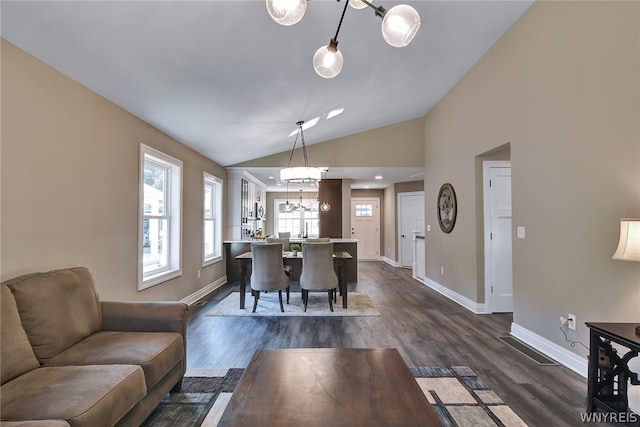 dining area featuring dark hardwood / wood-style flooring, a chandelier, and lofted ceiling