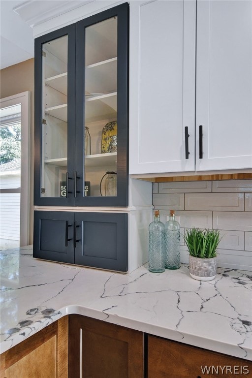 bar featuring white cabinetry and light stone countertops