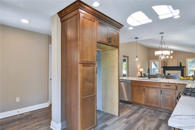 kitchen featuring lofted ceiling, sink, light stone countertops, appliances with stainless steel finishes, and dark hardwood / wood-style flooring