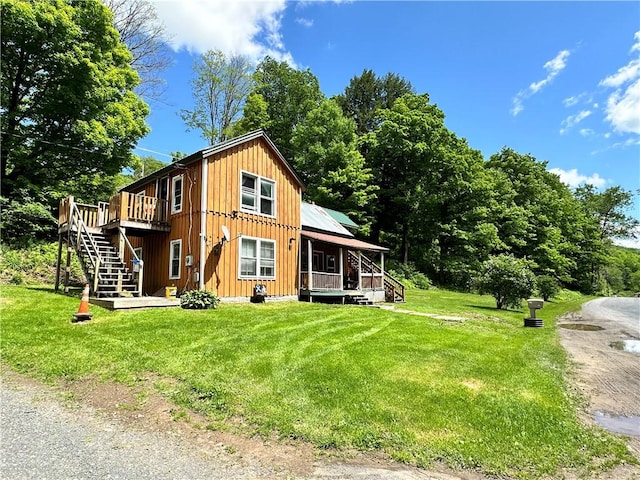 rear view of house with a yard and a deck