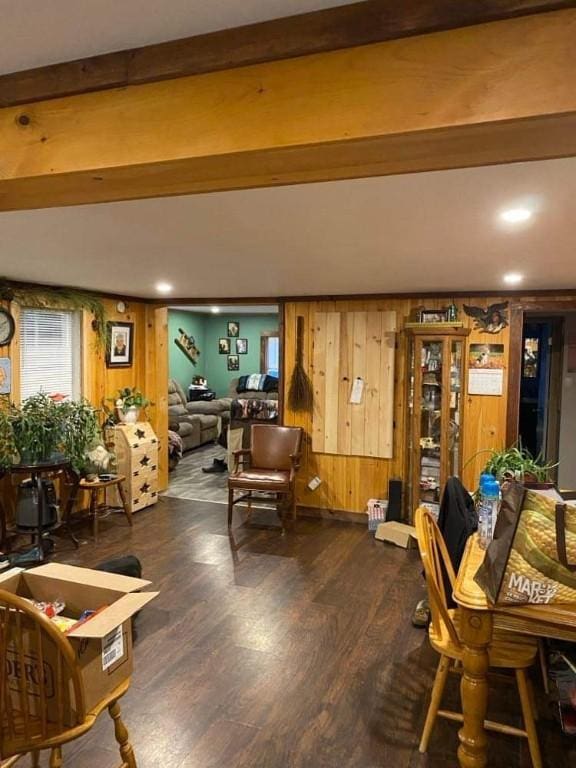 living room with beam ceiling, dark hardwood / wood-style flooring, and wooden walls