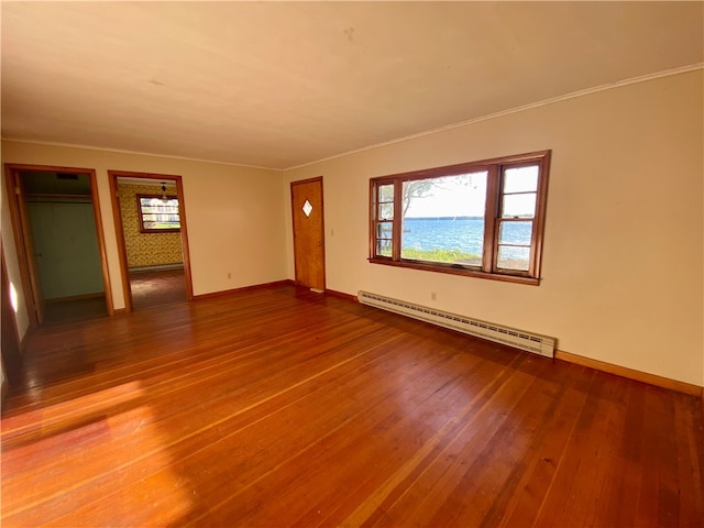 interior space with ornamental molding, a baseboard radiator, and hardwood / wood-style floors