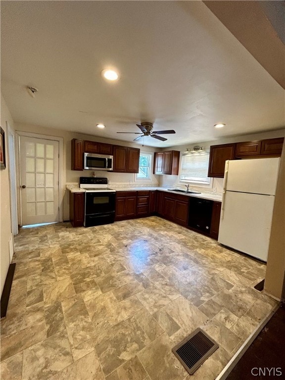 kitchen featuring dark brown cabinets, ceiling fan, white appliances, light tile flooring, and sink