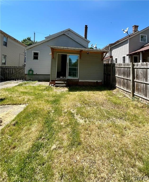 919 Lenox Ave, Utica, NY 13502 - back of property featuring a yard, entry steps, and fence