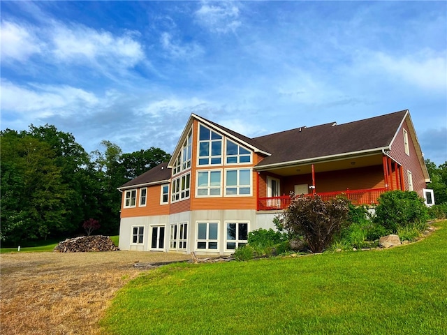 rear view of house featuring a lawn