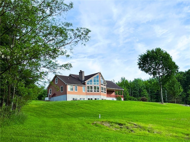 rear view of property featuring a lawn