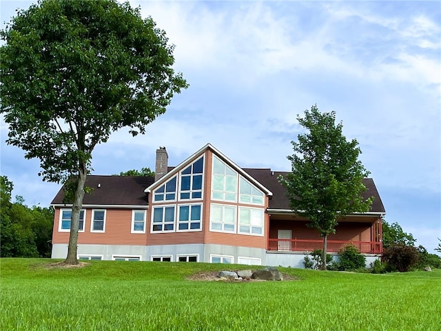 rear view of property featuring a lawn