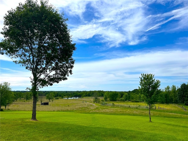 surrounding community with a rural view and a yard