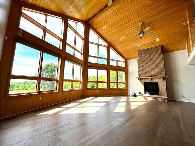 unfurnished living room featuring ceiling fan, wooden ceiling, a brick fireplace, high vaulted ceiling, and hardwood / wood-style floors