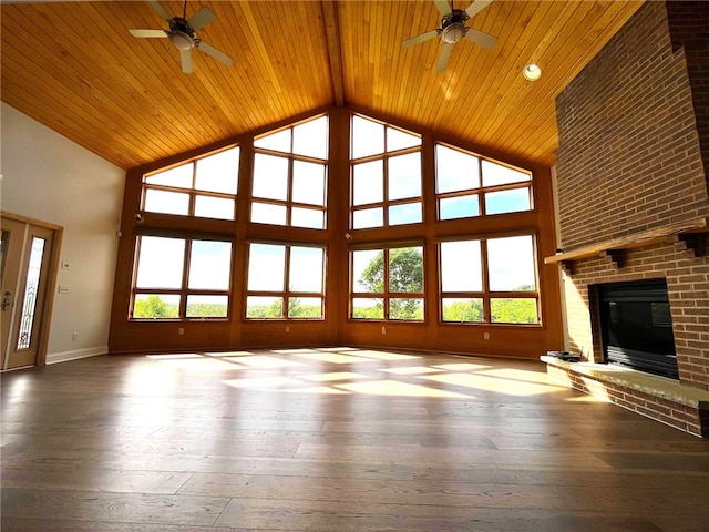 unfurnished living room with a wealth of natural light, a fireplace, hardwood / wood-style floors, and a high ceiling