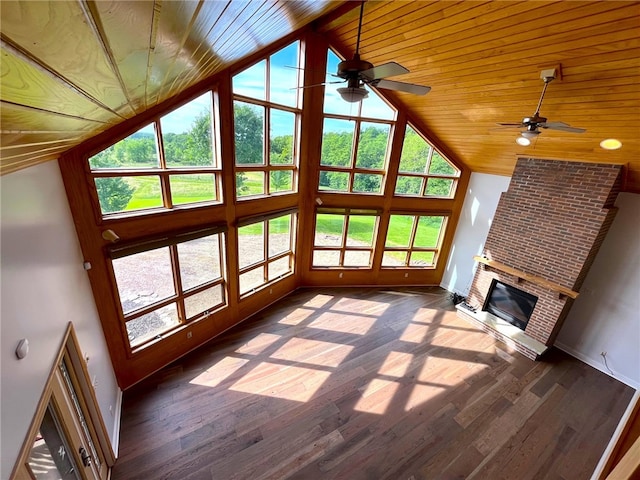 unfurnished living room featuring dark hardwood / wood-style flooring, wooden ceiling, plenty of natural light, and a brick fireplace