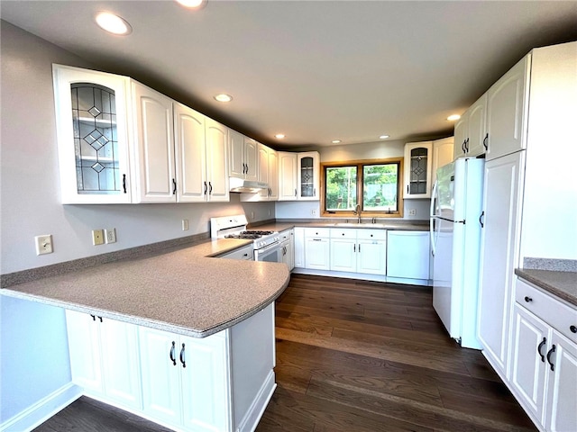 kitchen with white cabinetry, sink, dark wood-type flooring, kitchen peninsula, and white appliances