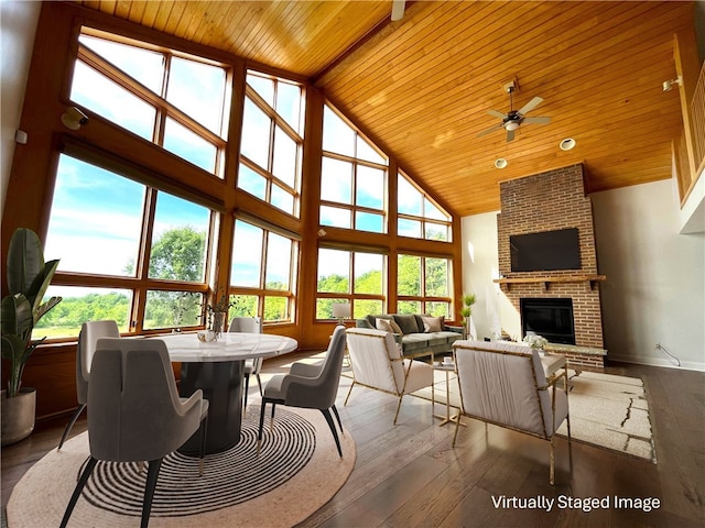 sunroom with a brick fireplace, ceiling fan, lofted ceiling, and wood ceiling