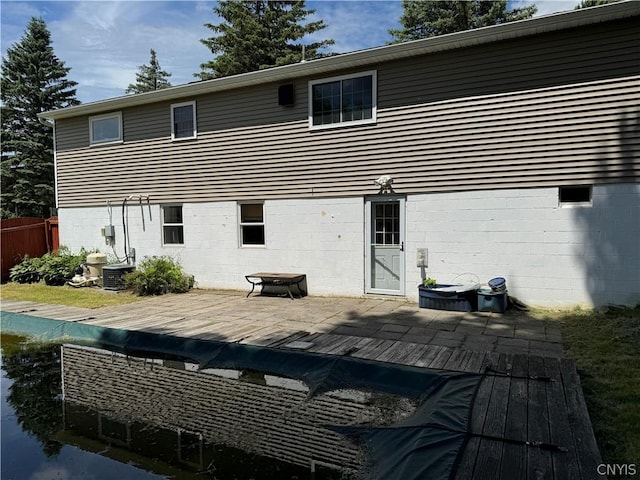 back of house with a deck and an outdoor fire pit