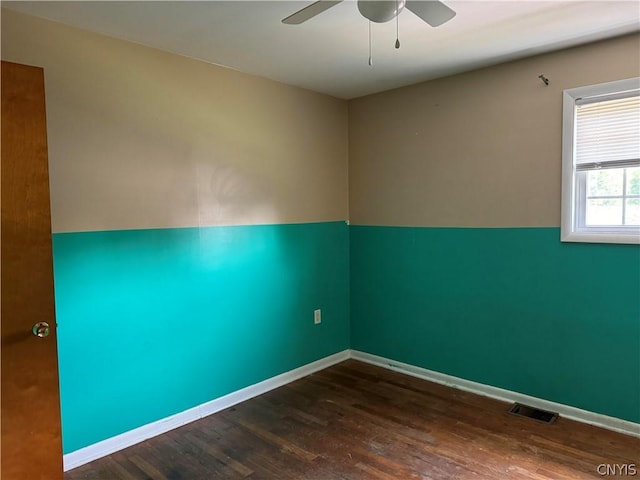 unfurnished room featuring dark wood-type flooring and ceiling fan