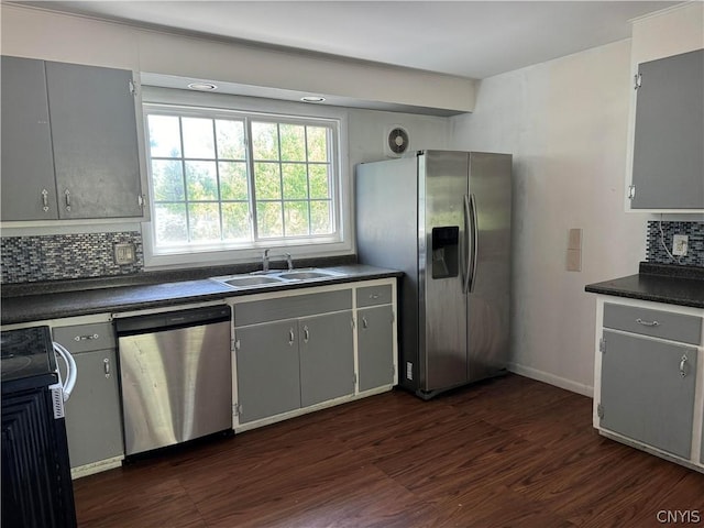 kitchen with stainless steel appliances, sink, gray cabinetry, and backsplash