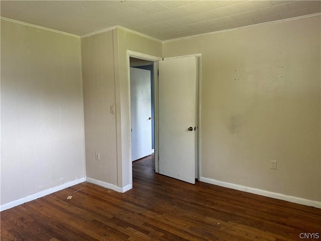 empty room with ornamental molding and dark hardwood / wood-style floors