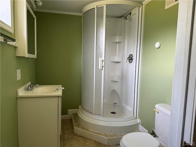 bathroom with toilet, a shower with shower door, crown molding, vanity, and tile patterned flooring