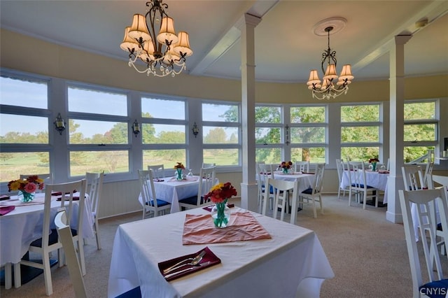 dining space featuring crown molding, light carpet, and a notable chandelier