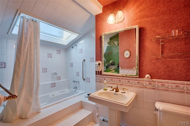 full bathroom with tile walls, vaulted ceiling with skylight, shower / bath combination with curtain, a baseboard radiator, and toilet