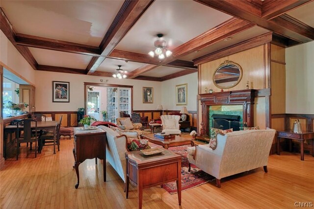 living room with coffered ceiling, a high end fireplace, light hardwood / wood-style flooring, and beamed ceiling