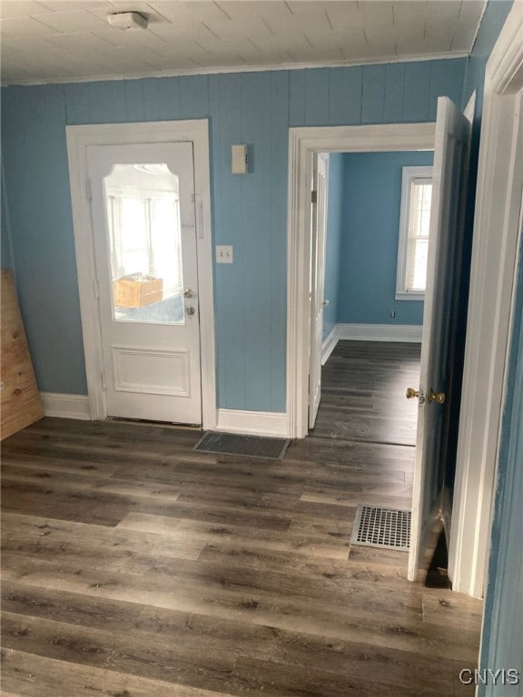 foyer with wood walls and dark hardwood / wood-style floors