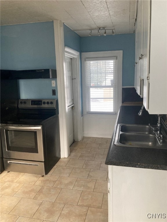 kitchen with extractor fan, track lighting, white cabinetry, stainless steel electric range oven, and sink