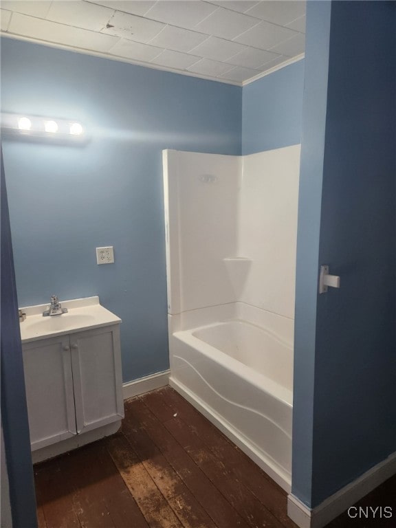 bathroom with wood-type flooring, vanity, and shower / tub combination