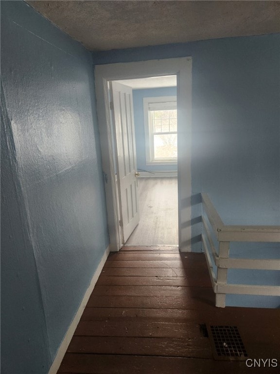 hallway featuring a textured ceiling and hardwood / wood-style floors