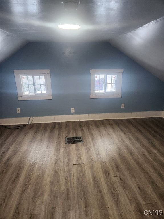 additional living space featuring vaulted ceiling and dark hardwood / wood-style floors