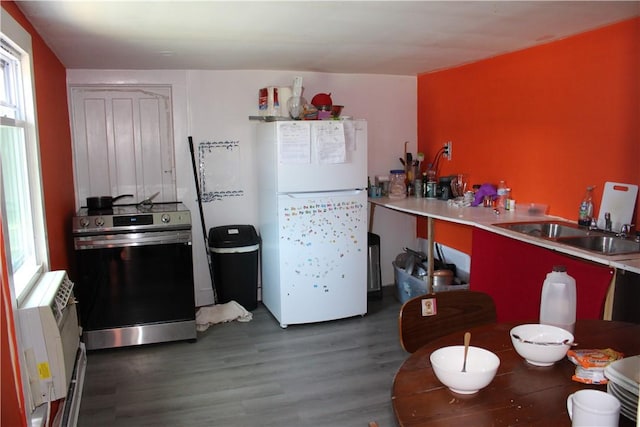 kitchen with dark wood-type flooring, radiator, white refrigerator, sink, and stainless steel stove