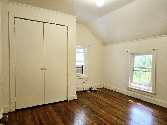 unfurnished bedroom with lofted ceiling, dark wood-type flooring, cooling unit, and a closet