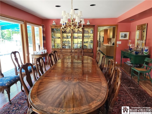 dining space featuring hardwood / wood-style flooring and an inviting chandelier